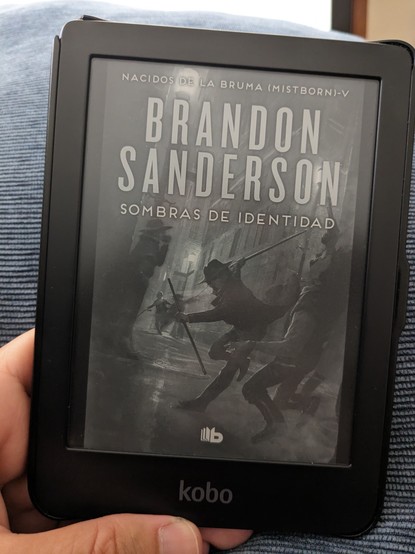 Ebook Kobo Clara mostrando la portada del libro "Sombras de identidad", quinta entrega de la saga Nacidos de la bruma, de Brandon Sanderson.