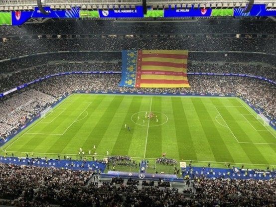 Panorámica del estadio Santiago Bernabéu con los jugadores ya saliendo al césped. El fondo sur muestra una pancarta que reza "Todos somos Valencia", pero es que luego también hay una desplegada bandera gigante de la Comunidad Valenciana que ocupa casi un lateral entero del estadio.