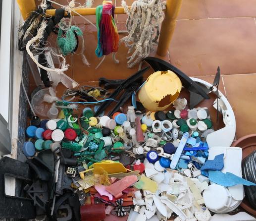 Plásticos medianos y pequeños de colores están desplegados en el suelo sobre una pequeña alfombra. 