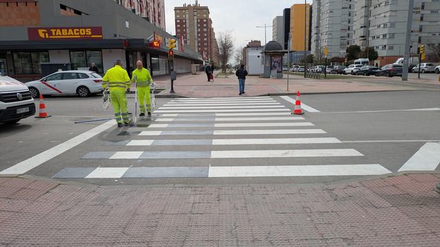 Dos operarios maravillosos retocan un paso peatonal para hacerlo también ciclista