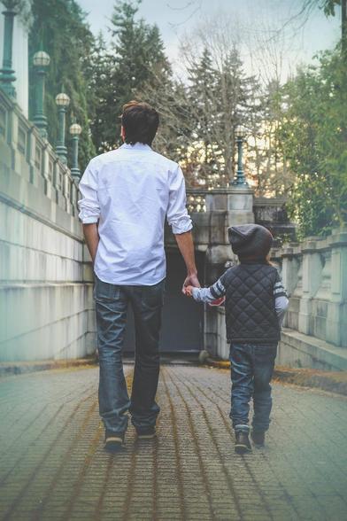 Padre e hijo caminado de la mano