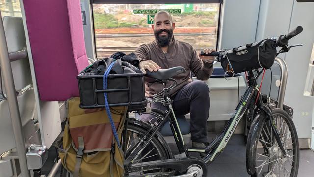 Una foto de mi en la Cercanías, con el outfit descrito y la bici en posición de descanso.