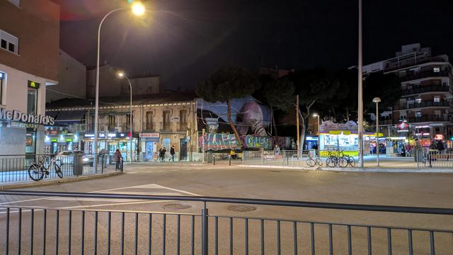Parada del metro de Carabanchel. Tres bicicletas descansan en aparcabicis universales. Una cuarta está atada a una valla de separación entre acera y calzada. Se ponen para que los peatones no molestemos a los coches.