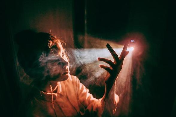Mujer mirando la luz que sale a través de un agujero