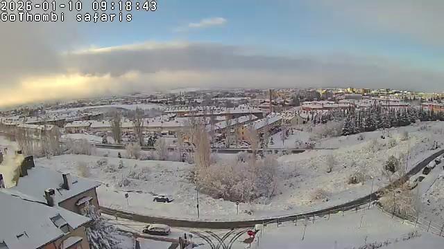 Vista de Jaca (Huesca) desde la base de la montaña de Rápitan. La escena está nevada, con el horizonte en medio mostrando un cielo nuboso amaneciendo por la izquierda.
